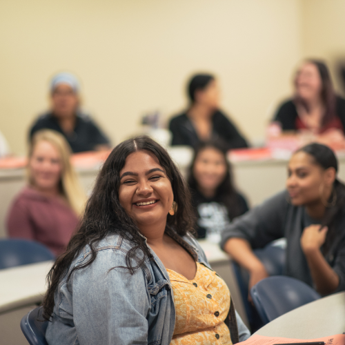 Image of student smiling at the camera in UCCS classroom.