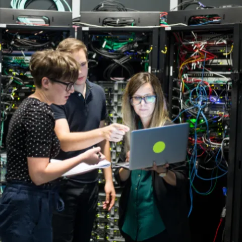 Group of professionals working in a server room.